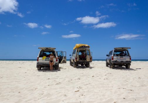 Cars parking on the main transportation highway on Fraser Island - wide wet sand beach coast facing Pacific ocean - long 75 miles beach