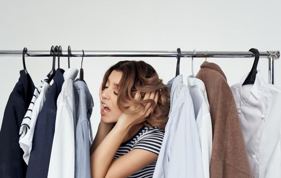 Woman in fitting room with clothes in hand shopping shirt