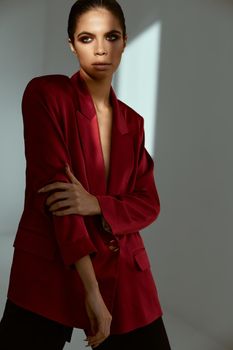 woman holding hand on her head red jacket fashion posing Studio
