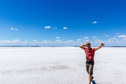 young man having fun on a salt lake and smiling in camera on a salt lake inwestern australia