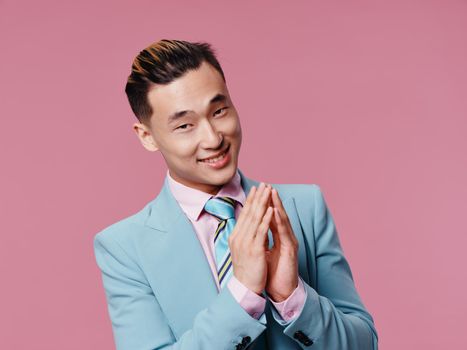 male asian appearance blue suit self confidence cropped view pink background