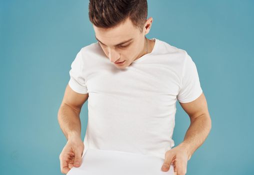 Male advertiser with a white sheet of paper on a blue background mockup Flyer