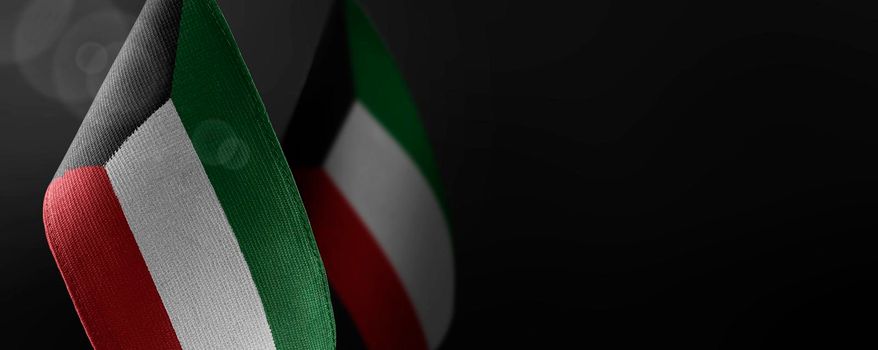 Small national flags of the Kuwait on a dark background