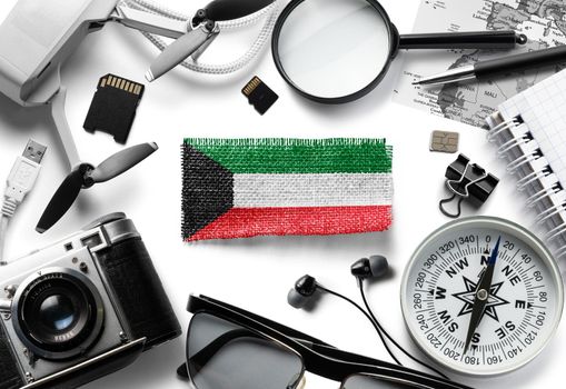 Flag of Kuwait and travel accessories on a white background.