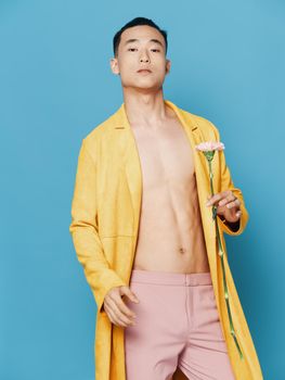 Korean man in a yellow coat with a flower in his hand and pink trousers