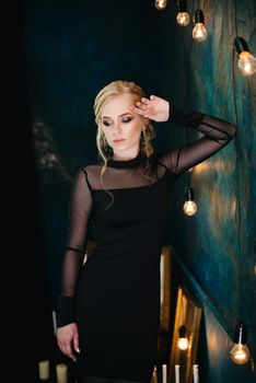 Blonde girl with blue eyes in a black dress