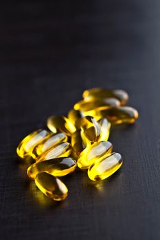 Omega-3 oil capsules and vitamin for health care on black board background.