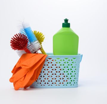 blue plastic basket with brushes, sponges and rubber gloves for cleaning