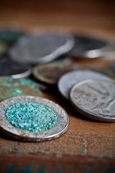 Pile of different ancient copper coins ccloseup on rustic wooden table background. 
