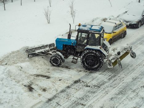 Tractor cleans the road from snow
