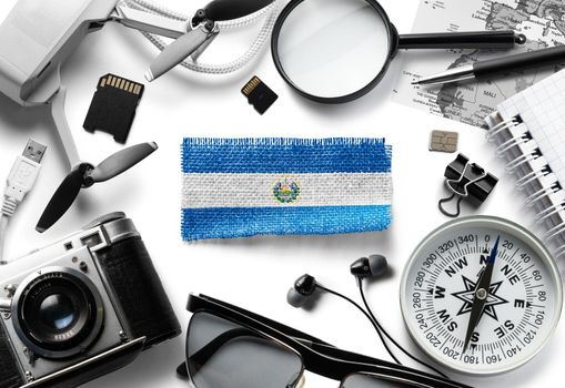Flag of Salvador and travel accessories on a white background.