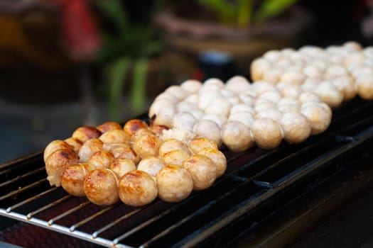 Meatballs are fried on an open-air stove at a street food market in Asia