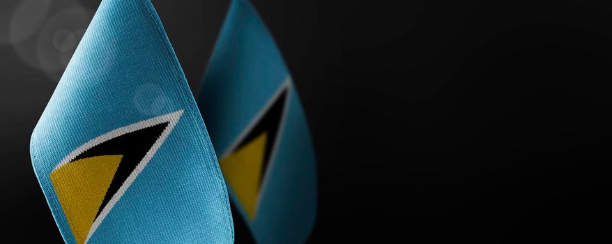 Small national flags of the Saint Lucia on a dark background