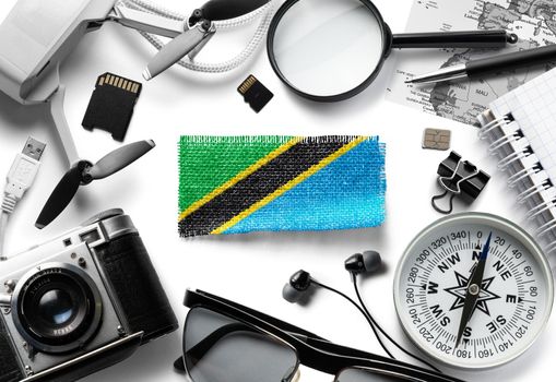 Flag of Tanzania and travel accessories on a white background.