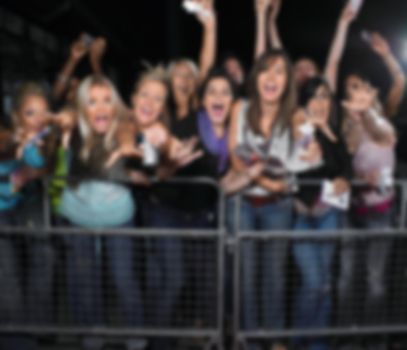 Blurred photo of group of fans screaming for their idol