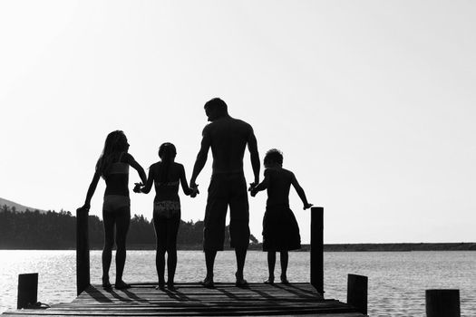 Black and white photo of happy family on pier