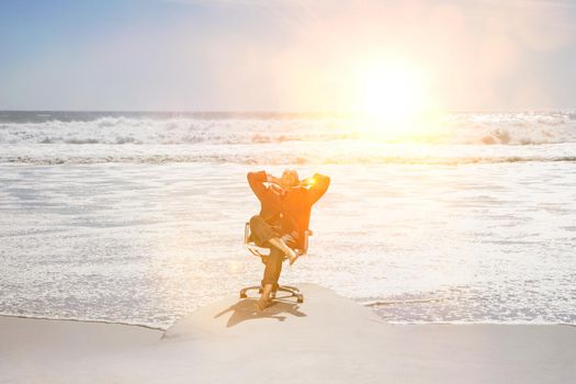 Middle aged businessman relaxing on office chair at beach