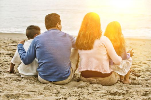 Family Sitting on the Beach with lens flare