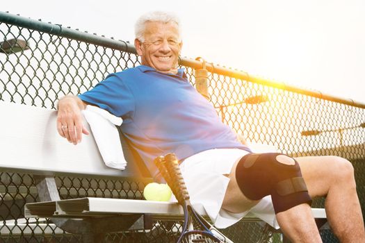 Man wearing knee band on tennis court