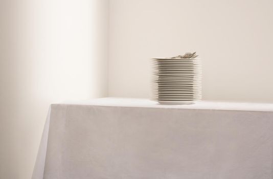 Stack of plates and cutlery on table