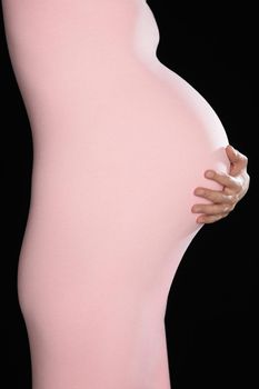 Pregnant woman in body suit holding abdomen