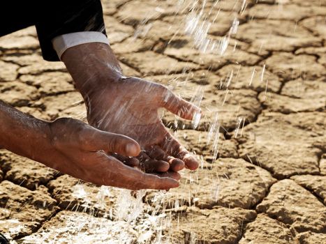 Business man washing hands in desert drought