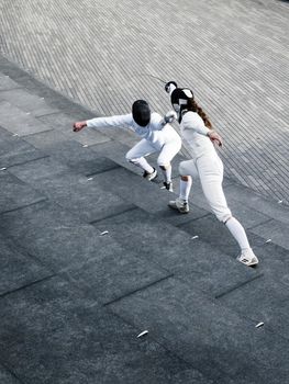 Two fencers fencing outside together