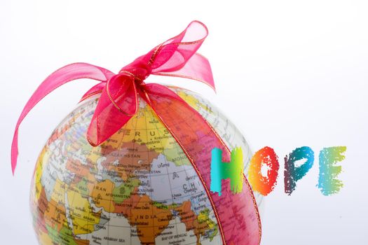 Globe tied with ribbon beside hope wording