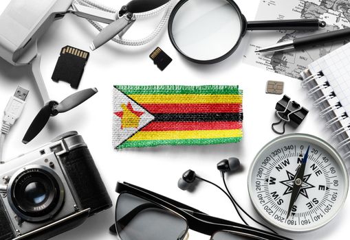Flag of Zimbabwe and travel accessories on a white background.