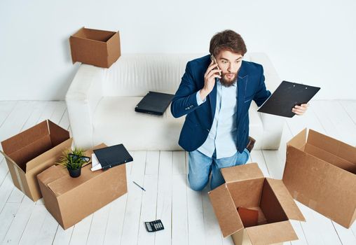 man talking on the phone unpacking boxes office work new place businessman