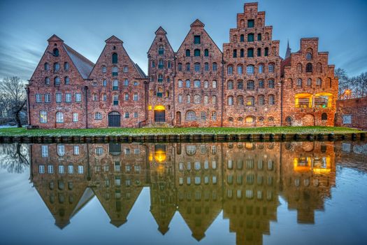The historic Salzspeicher reflecting in the Trave river at dawn