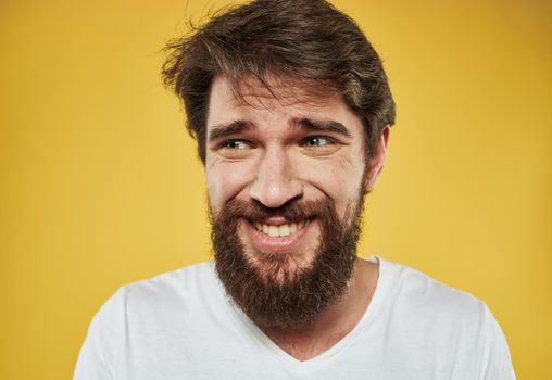 Emotional man with thick beard grinning model yellow background