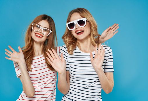 two pretty women gesticulate with hands fun friendship joy lifestyle blue background. High quality photo