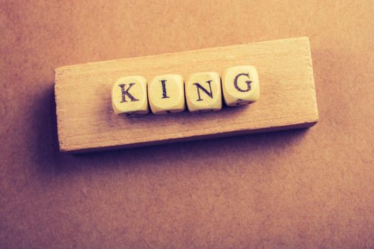 King wording with wooden cubes on wood