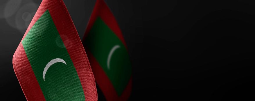 Small national flags of the Maldives on a dark background