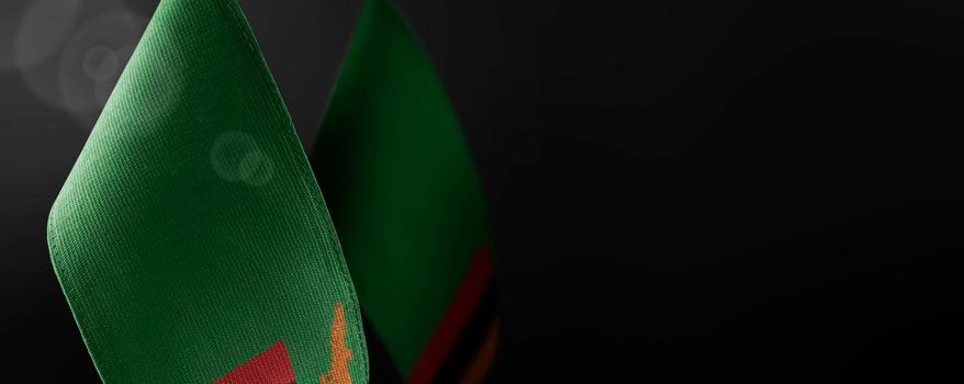 Small national flags of the Zambia on a dark background