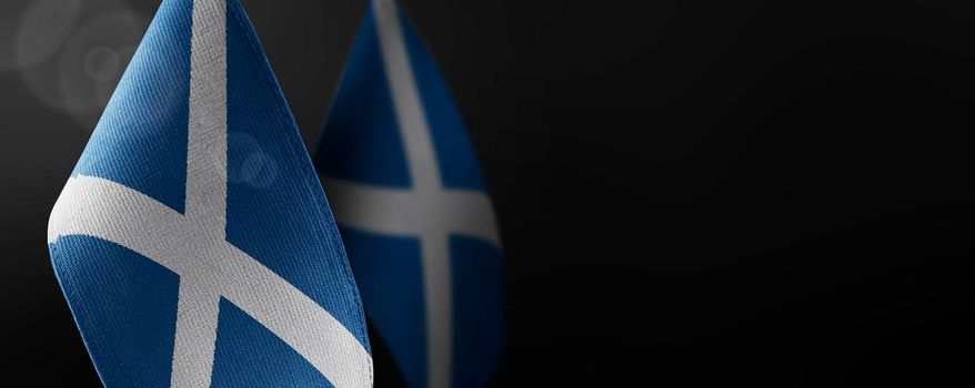 Small national flags of the Scotland on a dark background