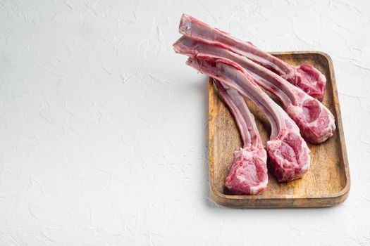Frenched raw fatty lamb chops, on white stone background , with copyspace and space for text