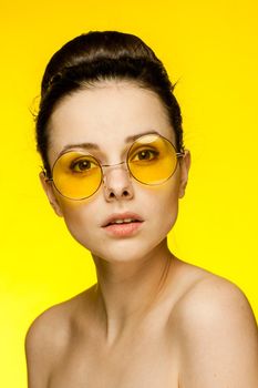 pretty woman with bare shoulders emotions fashionable yellow glasses cropped view