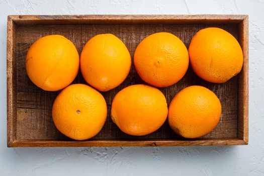 Florida county orange, healthy fruits, in wooden box, on white stone background, top view flat lay