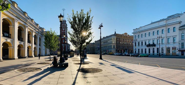 Russia, St.Petersburg, 02 June 2020: The architecture of Nevsky Prospect at sunset during pandemic of virus Covid-19, Square in front of Gostiny yard, long shadows of people and cars