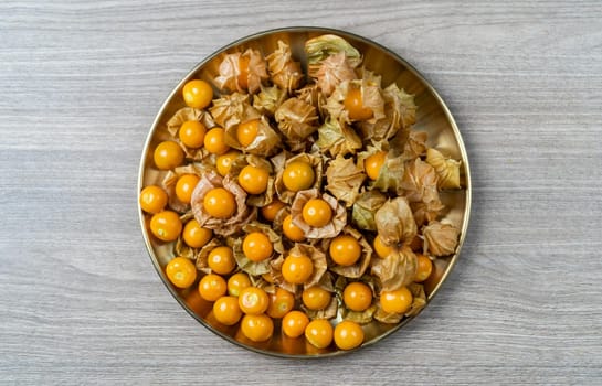 Top view pile of cape gooseberry fruit  in the gold plate.