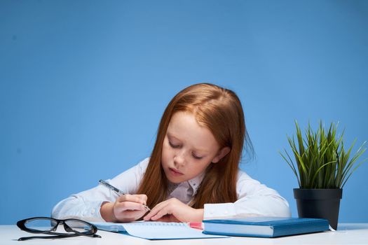 Girl sitting at the table and doing school education lessons. High quality photo
