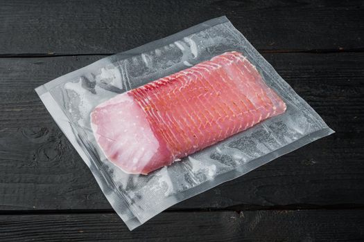 Balyk, Cured meat pork ham, vacuum packed, on black wooden table background