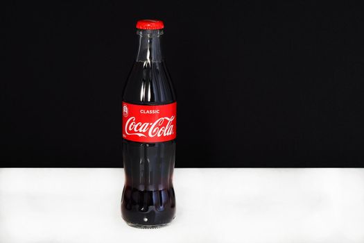 Coca cola in a glass bottle with the logo, isolated, on a black-and-white background. Editorial image. Russia, Nizhniy Novgorod 21.02.2021 G.