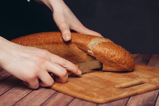 slicing a loaf on a wooden cutting board freshness