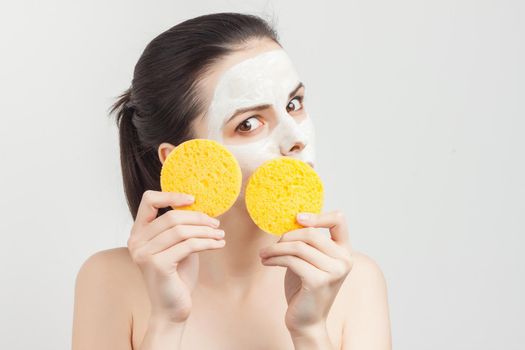 pretty woman with bare shoulders with bum in hands removing mask from face