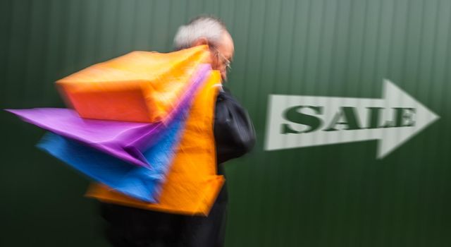 Holiday sales. An elderly man with many shopping bags in his hand