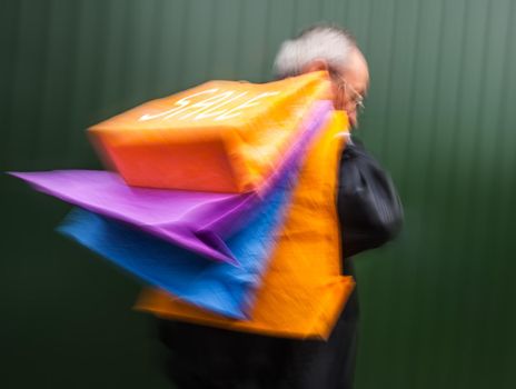 Holiday sales. An elderly man with many shopping bags in his hand