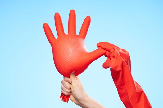 inflated rubber glove in hand house cleaning blue background